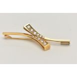 AN 18CT GOLD DIAMOND BROOCH, cross over style bar brooch, set with two rows of graduated round