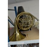 A FRENCH HORN AND CASE, made in Italy stamped 8970, gold lacquered, two mouth pieces, with a
