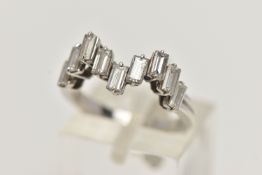 AN 18CT WHITE GOLD DIAMOND RING, designed with a wavy row of nine baguette cut diamonds, each in a