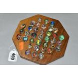 A SOLITAIRE BOARD WITH VINTAGE/ANTIQUE MARBLES, the wooden board containing thirty three handmade