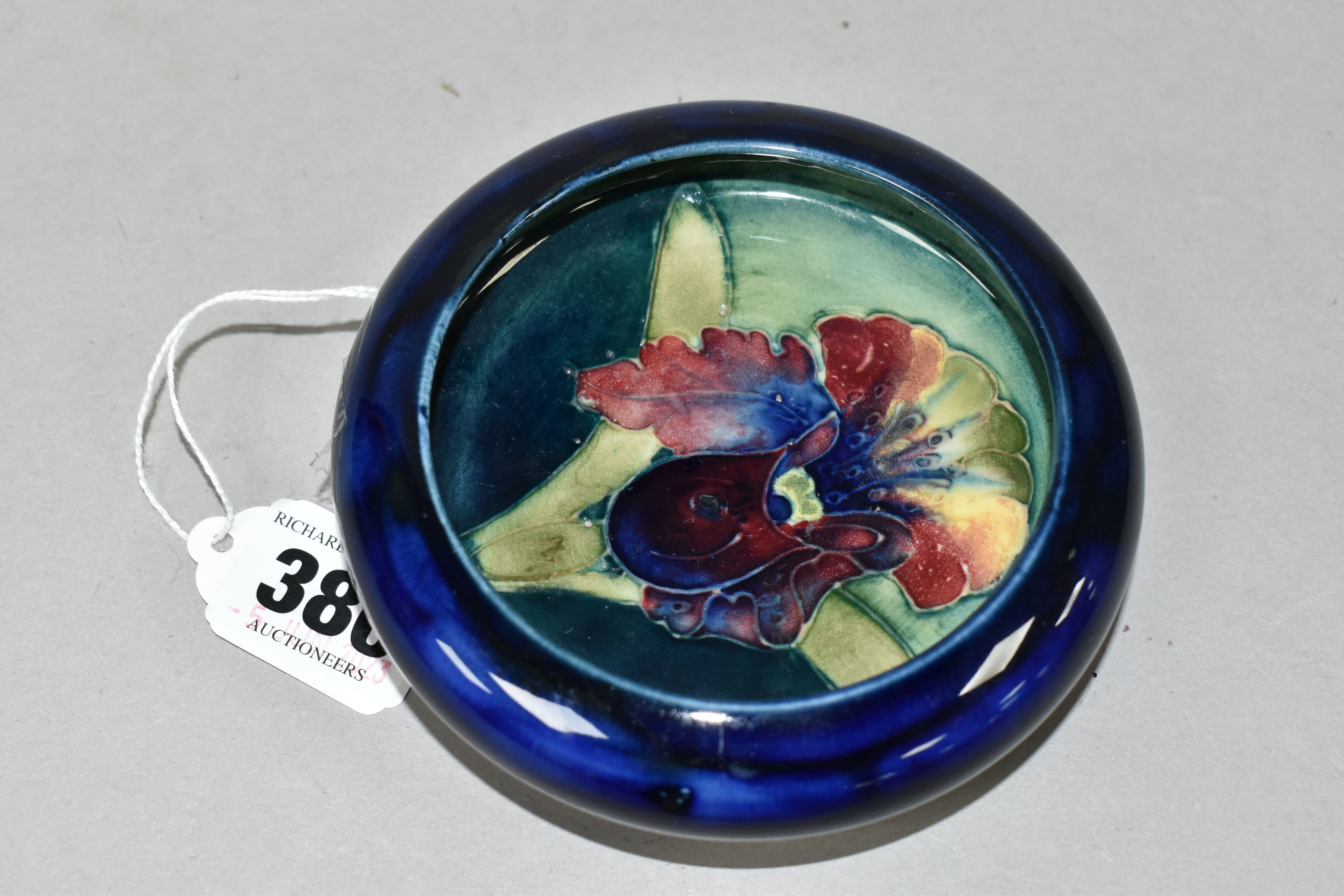 A MOORCROFT POTTERY 'ORCHID' PATTERN BOWL, tube lined with a purple and pale yellow orchid on a