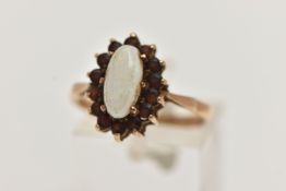 A 9CT GOLD CLUSTER RING, of an oval form, set with a central opal cabochon, in a surround of