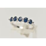 A WHITE METAL SAPPHIRE AND DIAMOND HALF ETERNITY RING, designed with a row of five oval cut blue