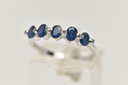 A WHITE METAL SAPPHIRE AND DIAMOND HALF ETERNITY RING, designed with a row of five oval cut blue
