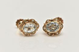 A PAIR OF NON-PIERCED, YELLOW METAL GEM SET EARRINGS, each of an oval outline, set with an oval