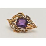 AN 18CT BI-COLOUR AMETHYST BROOCH, centring on a rectangular cut amethyst with cut off corners, four