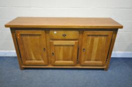A SOLID OAK SIDEBOARD, with a single central drawer, and three fielded panel cupboard doors, width