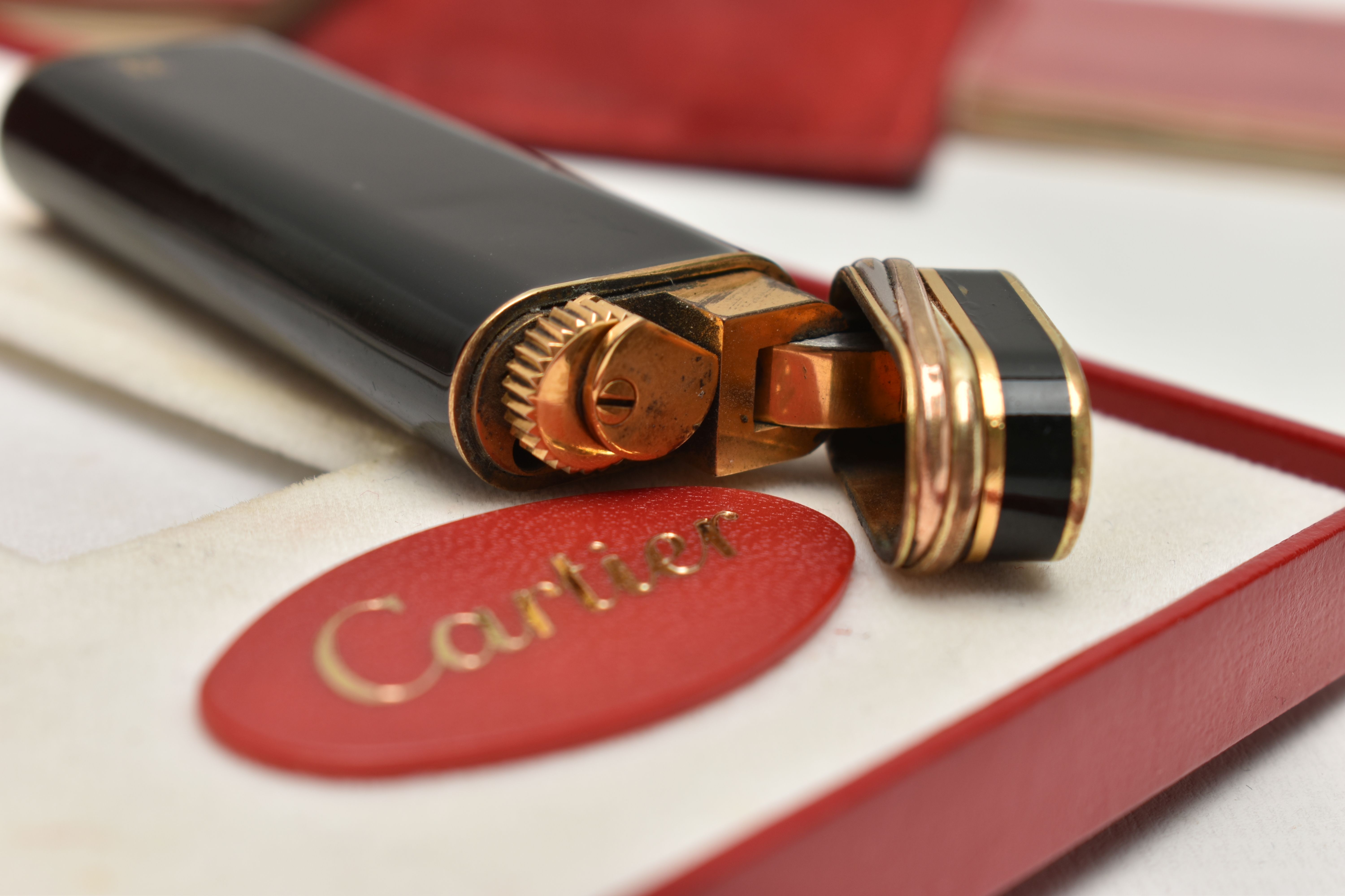 A 'MUST DE CARTIER' LIGHTER, gilt lighter with black lacquer and trinity band, serial 28008T, with a - Image 5 of 5