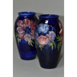 TWO MOORCROFT VASES, purple and mauve anemone design on a dark blue ground, height 19cm, blue