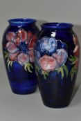 TWO MOORCROFT VASES, purple and mauve anemone design on a dark blue ground, height 19cm, blue