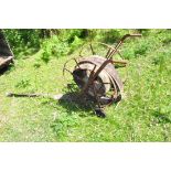 A VINTAGE FIRE HOSE REEL with distressed hose attached height 84cm Condition some pitted surface