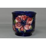 A MOORCROFT POTTERY FOOTED JARDINIERE, tube lined in Anemone pattern on a dark blue ground,