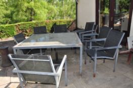 A DISTRESSED MODERN METAL AND GLASS GARDEN TABLE width and depth 137cm height 71cm and eight