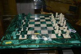 A MALACHITE AND HARDSTONE CHESS SET, the 37cm square board inlaid with brass stringing, height of