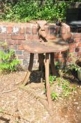 A VINTAGE CAST IRON LEG VICE ON STAND with a triform swept leg base and Demi lune top width 53cm