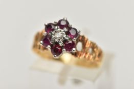 A YELLOW METAL DIAMOND AND RUBY CLUSTER RING, centrally set with a single cut diamond illusion