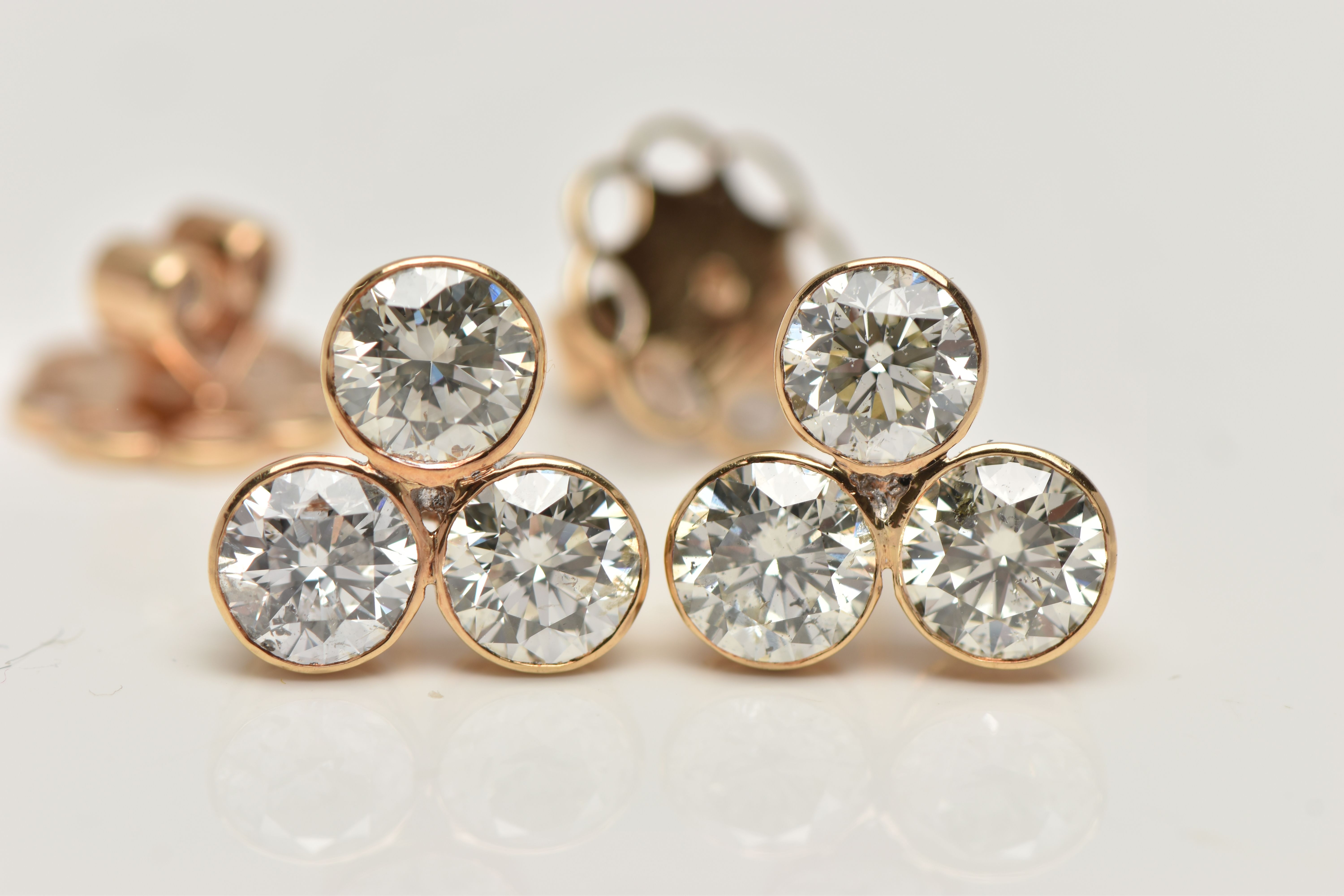 A PAIR OF 6 CARAT DIAMOND STUD EARRINGS, each earring comprising of three round brilliant cut