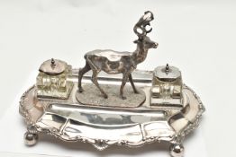 A LATE VICTORIAN SILVER PLATE DESK STAND, featuring a stag to the centre, with two glass ink jars