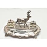 A LATE VICTORIAN SILVER PLATE DESK STAND, featuring a stag to the centre, with two glass ink jars