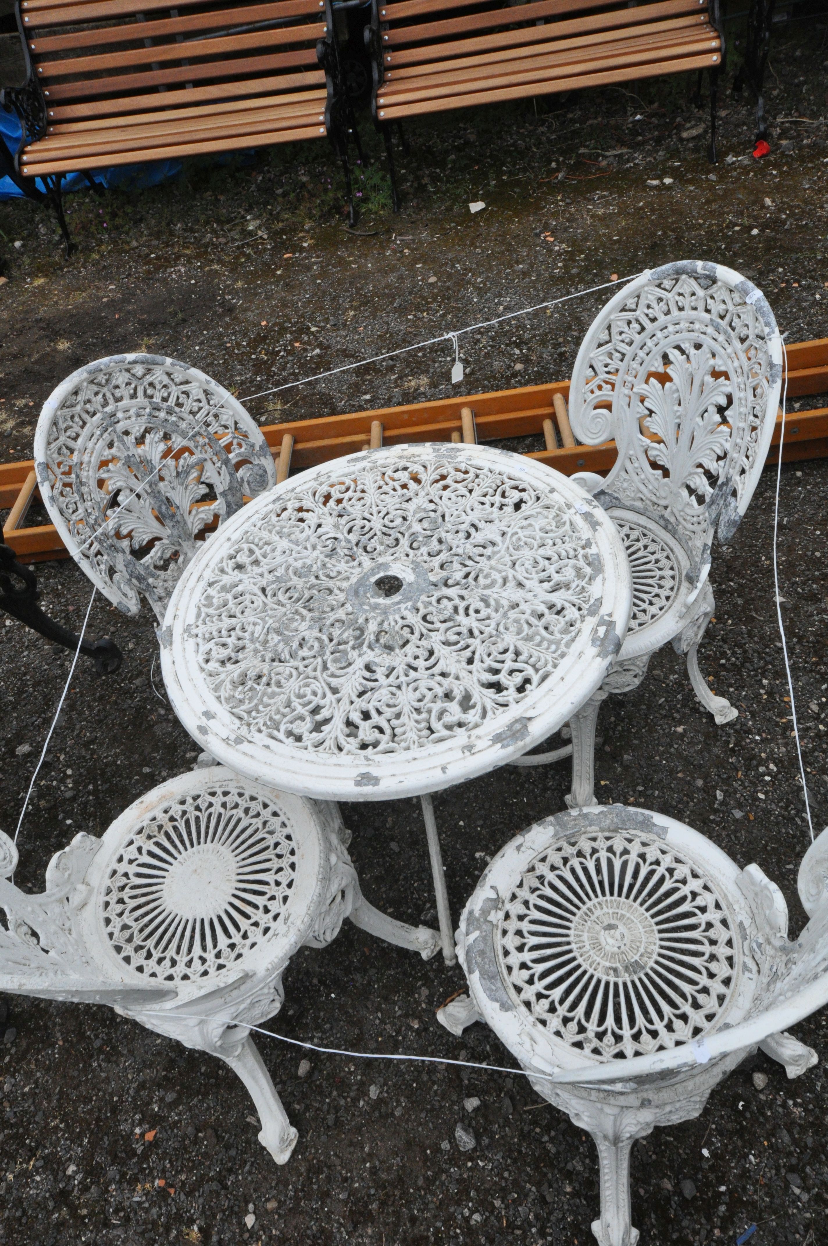 A WHITE PAINTED CAST ALUMINIUM CIRCULAR GARDEN TABLE, diameter 69cm x height 66cm, along with four