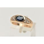 A YELLOW METAL SAPPHIRE AND DIAMOND RING, designed with a central oval cut deep blue sapphire,