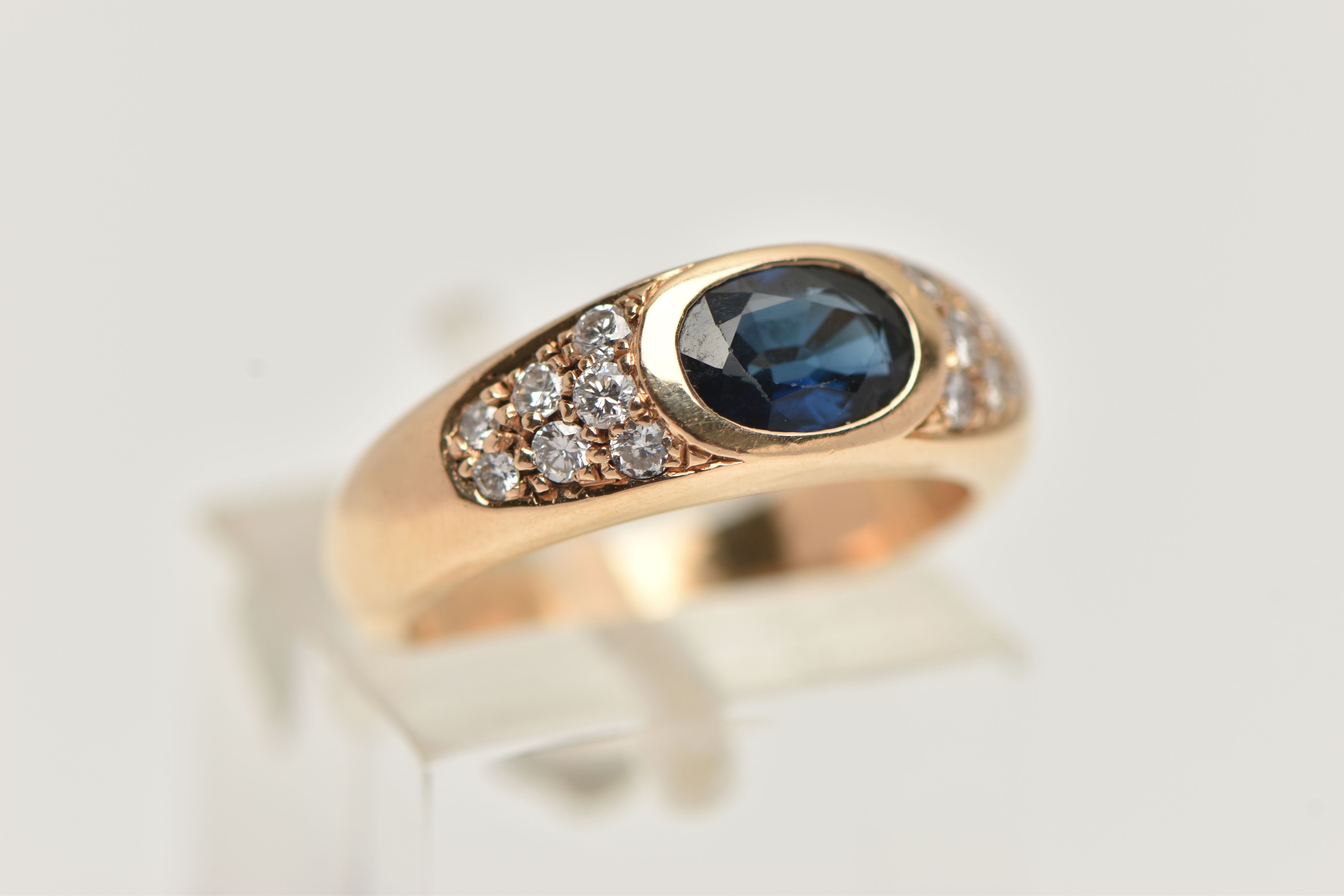 A YELLOW METAL SAPPHIRE AND DIAMOND RING, designed with a central oval cut deep blue sapphire, - Image 4 of 4