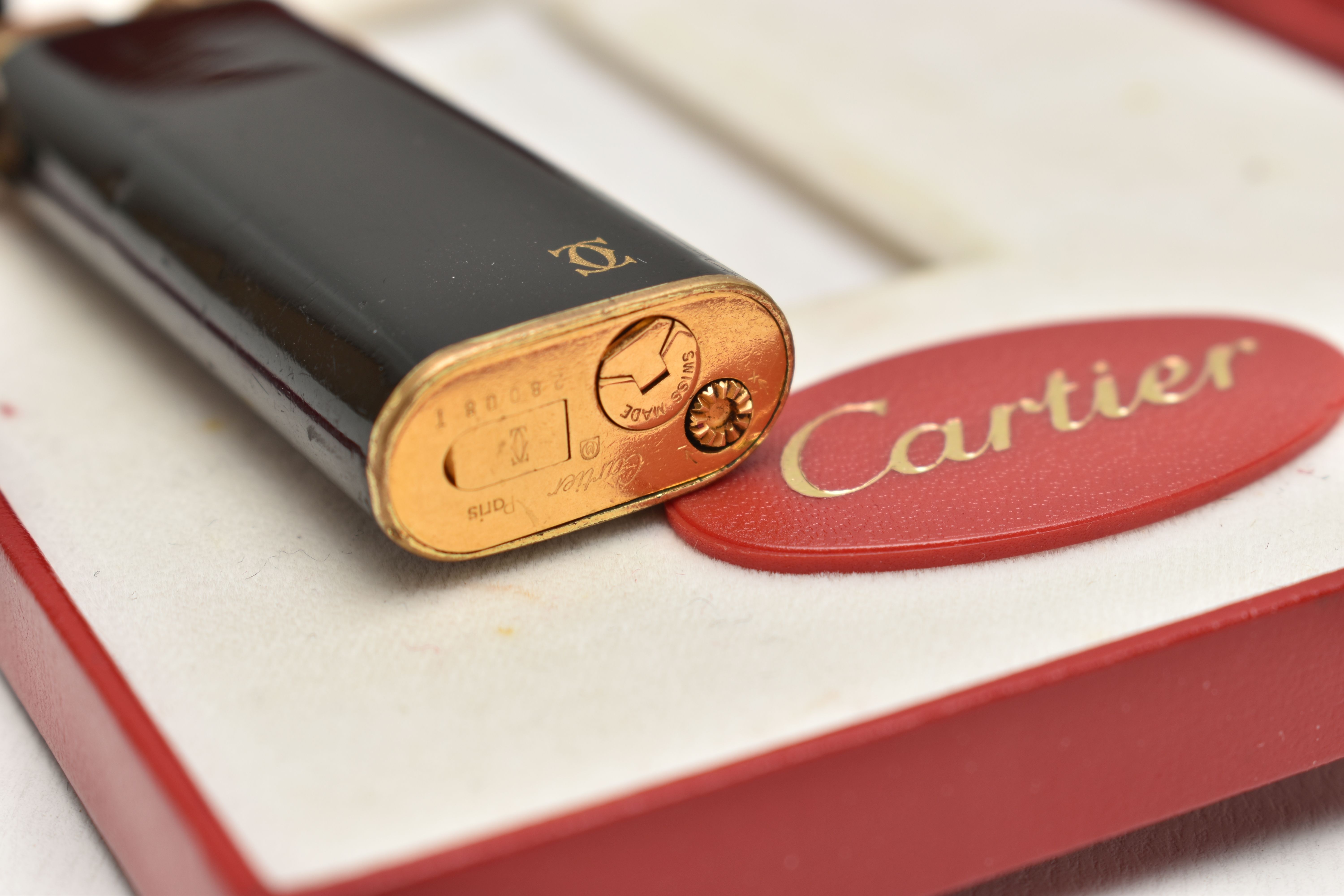 A 'MUST DE CARTIER' LIGHTER, gilt lighter with black lacquer and trinity band, serial 28008T, with a - Image 4 of 5