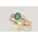 AN 18CT EMERALD AND DIAMOND RING, designed with a central oval cut emerald, claw set, flanked with