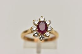 A MODERN RUBY AND DIAMOND CLUSTER RING, a principle oval cut ruby, approximate length 7mm x width