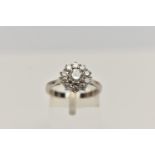 A MODERN DIAMOND CLUSTER RING, a principle round brilliant cut diamond prong set in white metal,