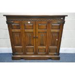 AN OLD CHARM OAK LINENFOLD DOUBLE BIFOLD DOOR CD CABINET, width 104cm x depth 28cm x height 90cm (