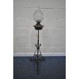AN ARTS AND CRAFTS WROUGHT IRON TELESCOPIC OIL LAMP, with a glass shade, funnel and brass reservoir,