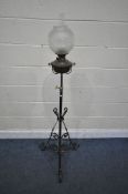 AN ARTS AND CRAFTS WROUGHT IRON TELESCOPIC OIL LAMP, with a glass shade, funnel and brass reservoir,
