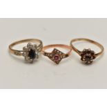 THREE YELLOW METAL RINGS, the first a garnet cluster ring, stamped gold, ring size O, a sapphire and