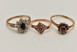 THREE YELLOW METAL RINGS, the first a garnet cluster ring, stamped gold, ring size O, a sapphire and