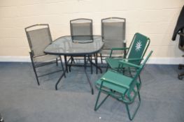 A HOMEBASE GLASS TOPPED GARDEN TABLE with three matching chairs and two other folding chairs