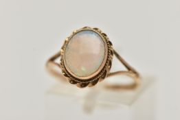 A 9CT GOLD OPAL RING, oval cut opal cabochon, collet set with a fine rope twist surround, bifurcated