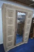 A FRENCH OAK TRIPLE DOOR WARDROBE, with a central wavy bevelled edge mirror, width 149cm x depth
