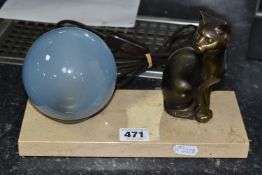 A FRENCH ART DECO TABLE LAMP, featuring a seated cat figure and a blue glass globe shade on a