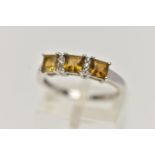 A 9CT WHITE GOLD GEM SET RING, designed with three claw set, square cut citrines, interspaced with