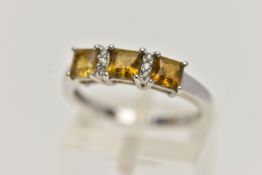 A 9CT WHITE GOLD GEM SET RING, designed with three claw set, square cut citrines, interspaced with