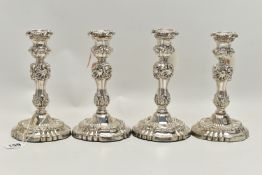 A SET OF FOUR GEORGE IV SILVER CANDLESTICKS, circular form with foliage and scrolling detail to