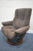 AN EKORNES STRESSLESS BROWN SUEDE RECLINING ARMCHAIR, and a matching stool (condition report: -suede