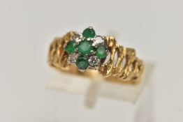 A YELLOW METAL GEM SET CLUSTER RING, flower cluster set with circular cut emeralds and diamonds,