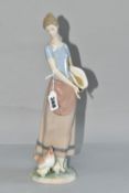 A LLADRO 'COUNTRY CHORES' FIGURINE, depicting a female figure feeding chickens, model no 6370,