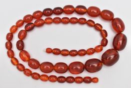 A STRING OF GRADUATED BAKELITE BEADS, graduating light red oval beads, largest measuring 25.4mm x