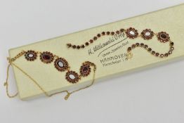A YELLOW METAL GARNET NECKLACE AND A BRACELET, the necklace fitted with five oval garnet cluster