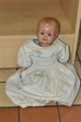 A HUGO WIEGARD DOLL, with bisque head, closing eyes, an open mouth showing two teeth, composite body