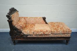 A VICTORIAN CARVED MAHOGANY DAY BED/CHAISE LONGUE, decorated with mythical creatures, foliate and