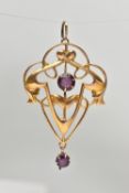 A LAVALIER PENDANT, the scrolling foliate design set with a central circular purple paste and